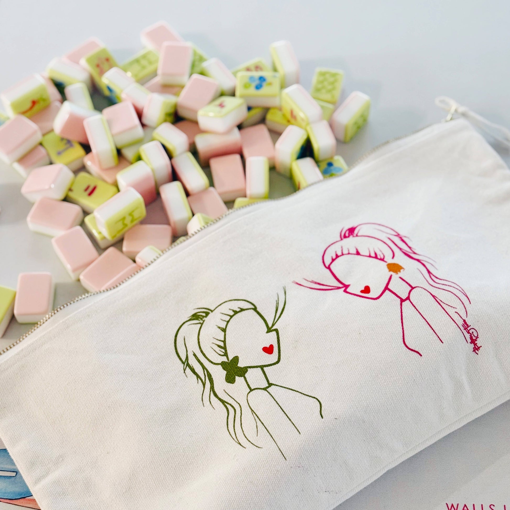 Canvas pouch with illustrations of girls and colorful candies on a light gray background
