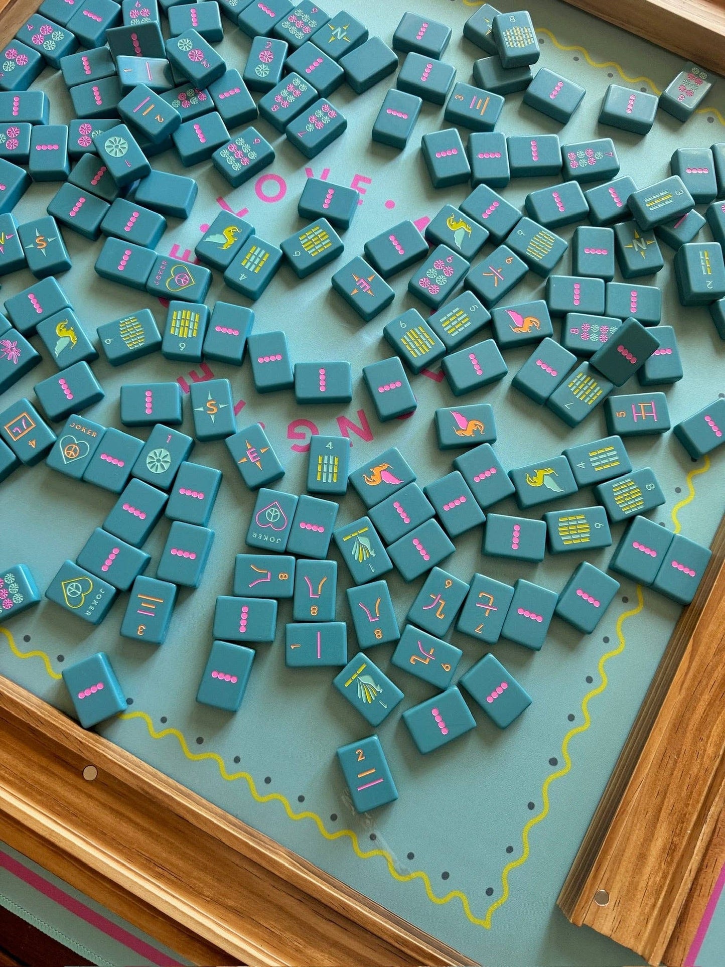 Teal mahjong tiles on a green mat