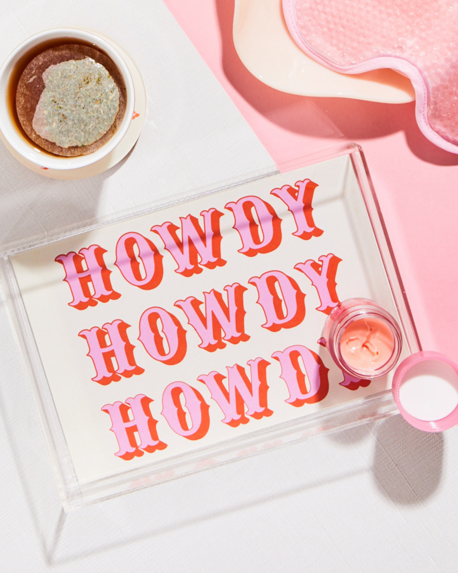 Acrylic jewelry tray with 'HOWDY' text on a pink background
