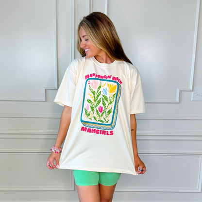 Woman wearing a white t-shirt with a colorful graphic and text, standing against a white wall. Mahjong with Mah Girls