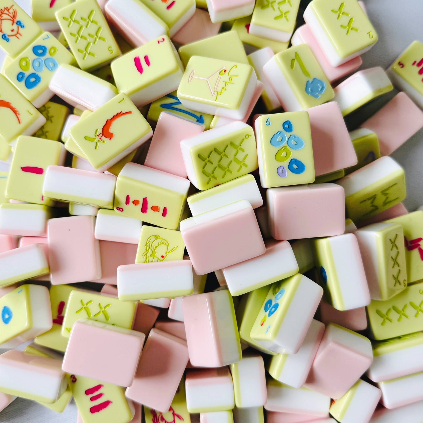 Colorful mahjong tiles with various designs on a white background